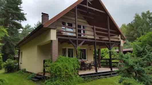 una casa con un gran techo de gambrel en Kofi Garden en Dębki