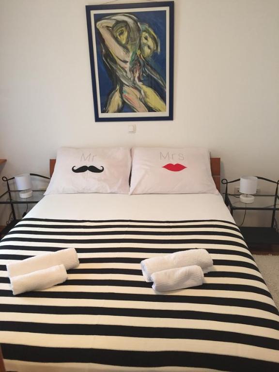 a bedroom with a black and white striped bed with two towels at Apartment 4 you in Split