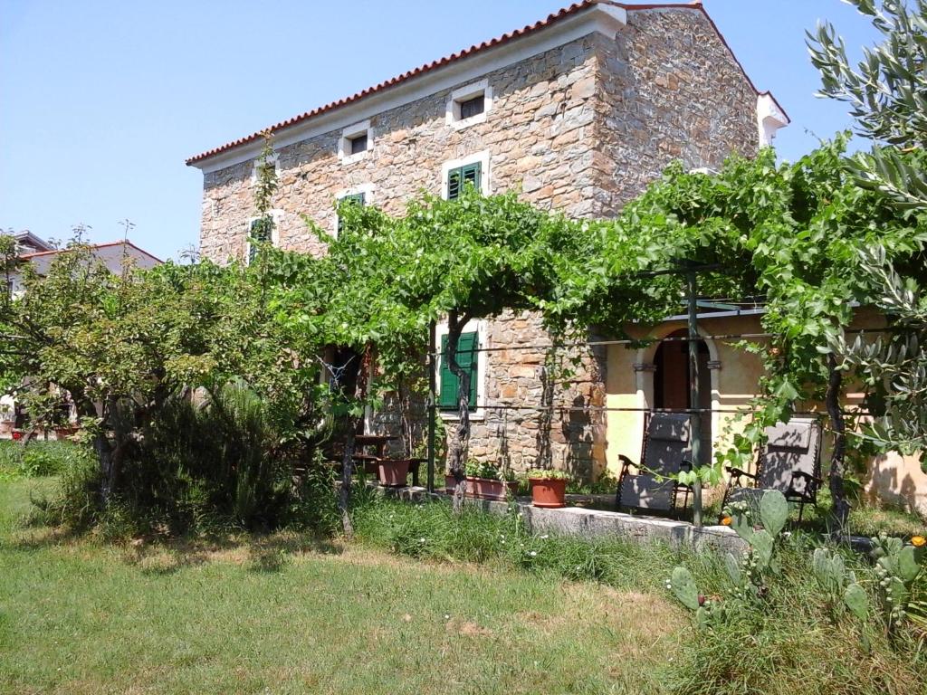 an old stone house with trees in front of it at Kmetija Medljan in Izola