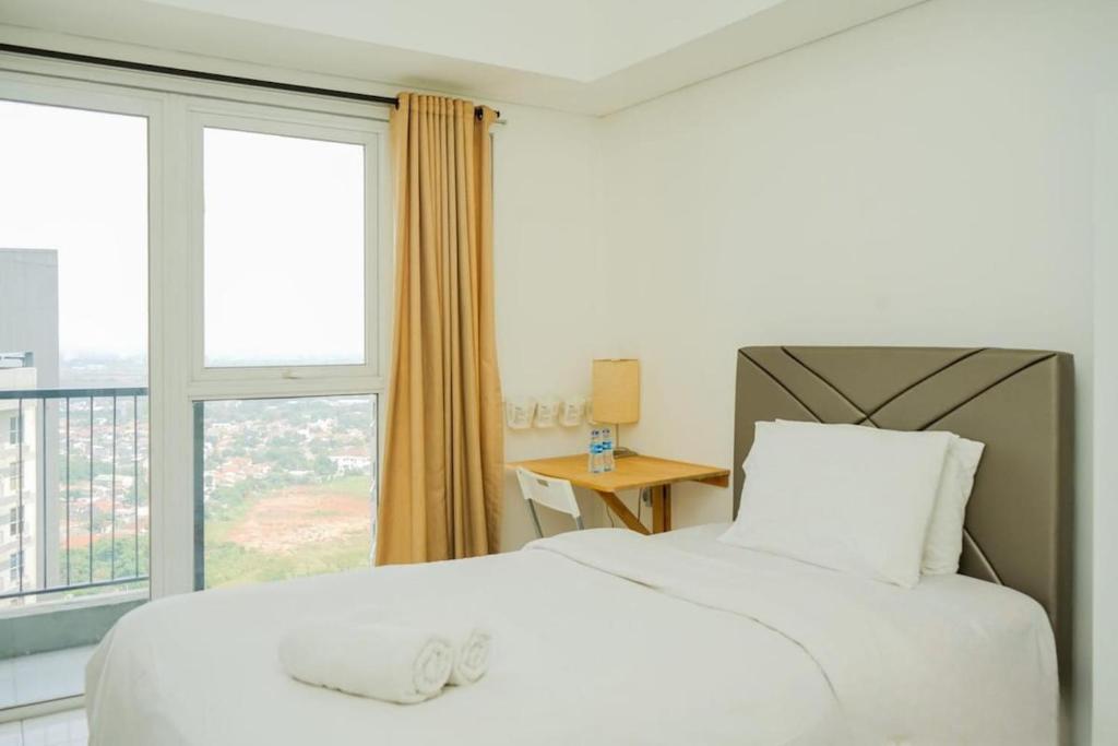 une chambre avec un lit blanc et une grande fenêtre dans l'établissement Cozy Studio near ICE BSD & AEON Mall, à Samporo