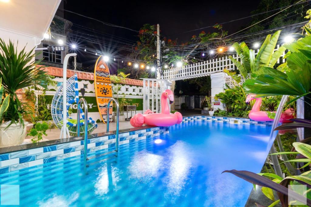 a pool at night with pink flamingos and a water park at Villa Khu Á Châu Hồ Bơi có Sân bbq in Vung Tau