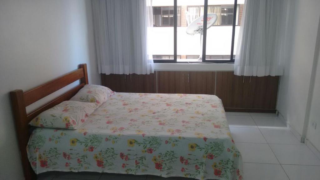 a bedroom with a bed and a window at Estúdio Ibiza II in Maceió