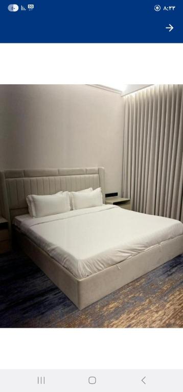 a bed with white sheets and pillows in a room at بيتوتات التيسير in Jeddah