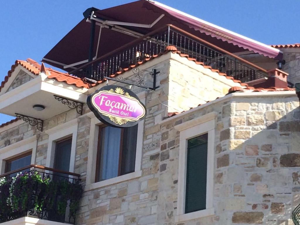 a sign on the side of a house at Focamor Otel in Yenifoça