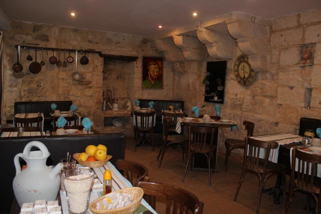 サン・レミ・ド・プロヴァンスにあるLes Suites de Naevagの石壁の部屋にテーブルと椅子が備わるレストラン
