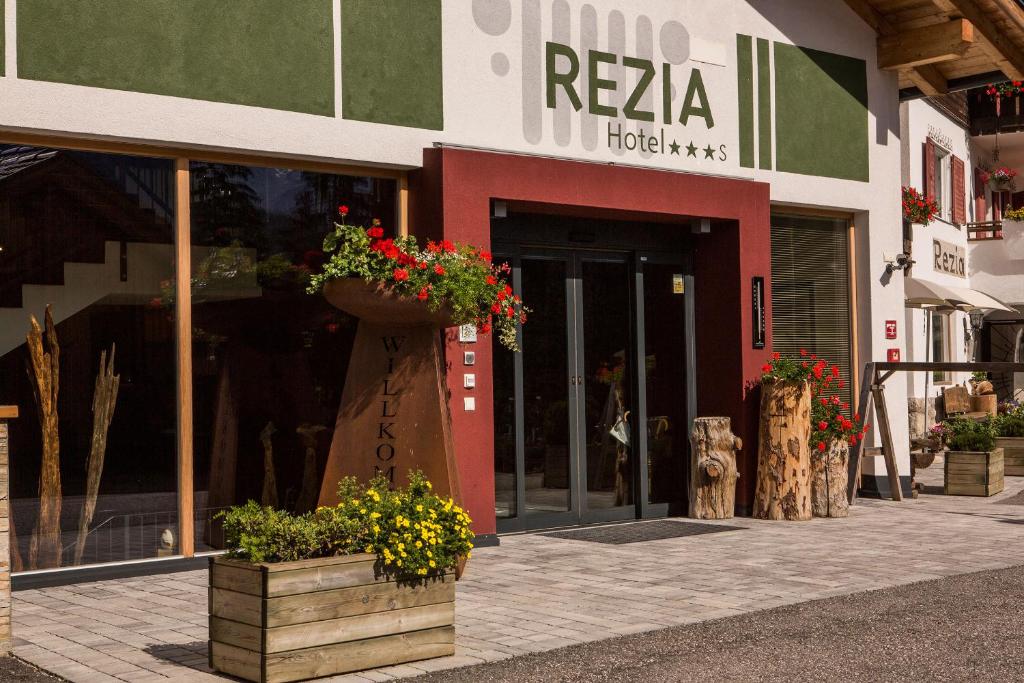 a store with potted plants in front of a building at Hotel Rezia in La Villa