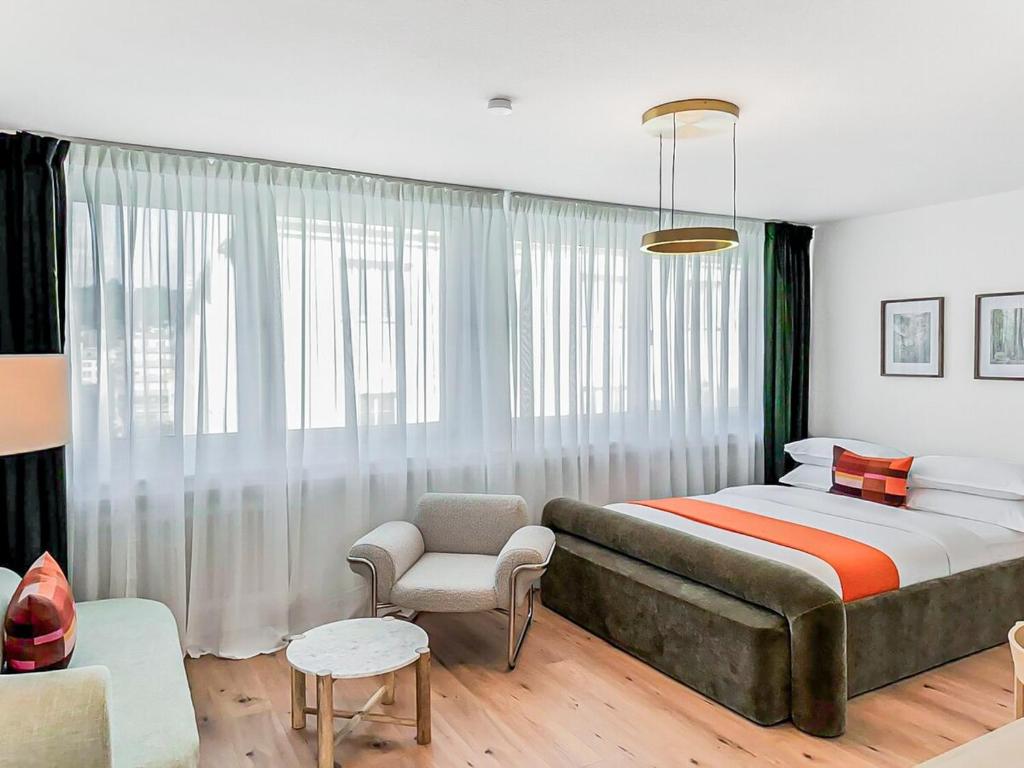 a bedroom with a large bed and a chair at Chic City Apartment, 1BR for 2, Elegant Comfort in Wuppertal