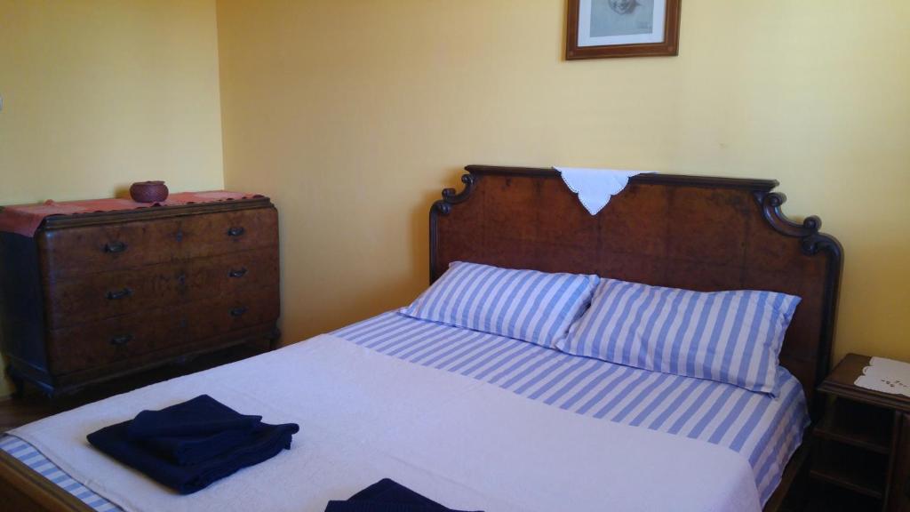 a bedroom with a bed with a wooden headboard and a dresser at Maestral in Koper