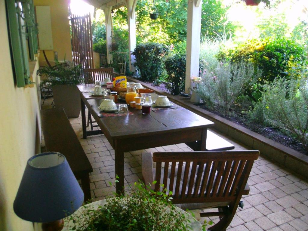une table et des chaises en bois sur une terrasse dans l'établissement Le Bord de l'eau, à Sainte-Terre
