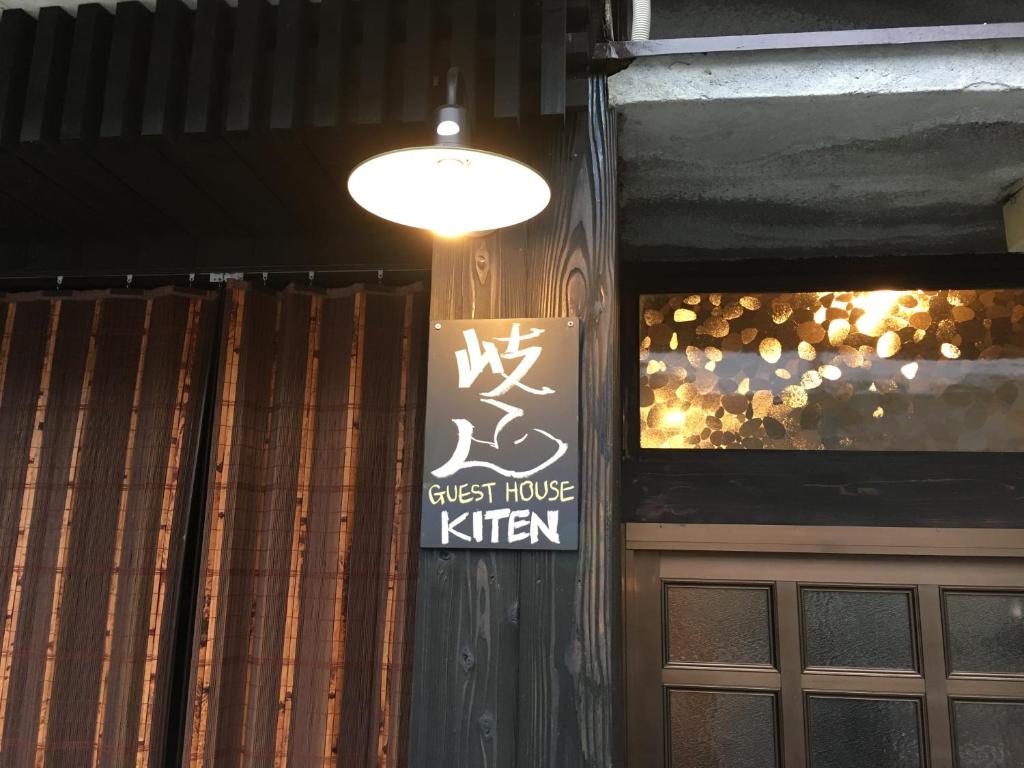 a sign for a guest house kitchen hanging on a wall at Guesthouse Kiten in Gifu