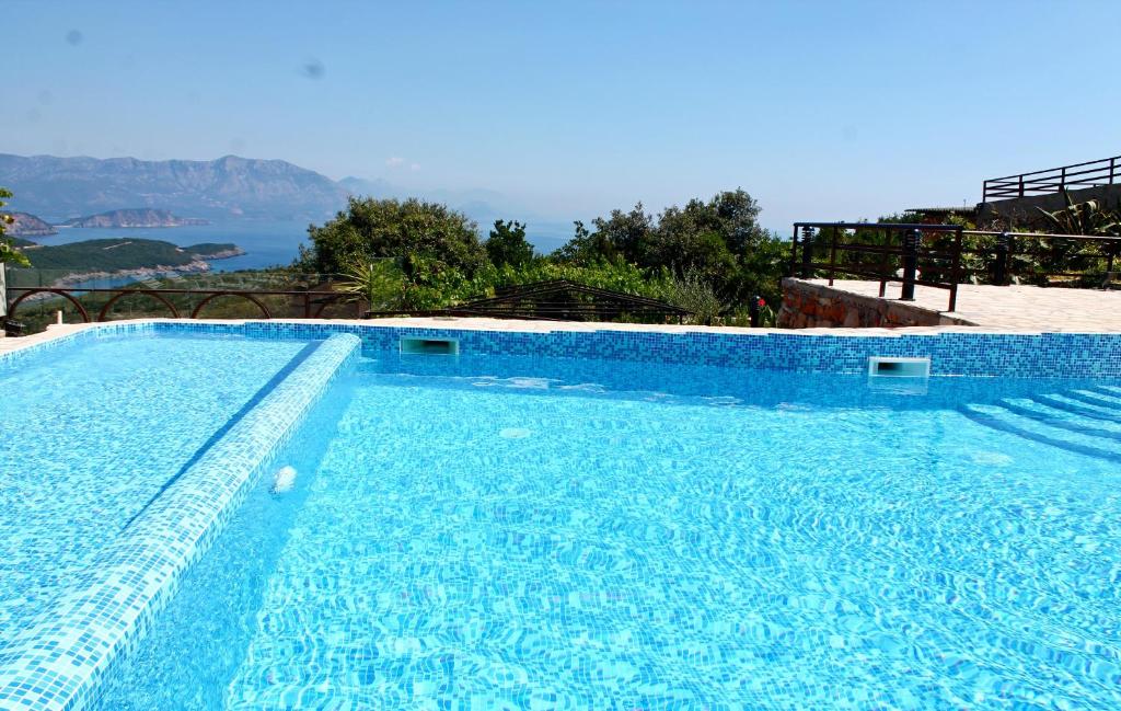 a blue swimming pool with a view of the ocean at Apartments Villa Milna 1 in Budva