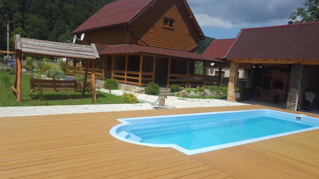 una casa con piscina frente a un edificio en Guest House in Carpathians, en Migovo