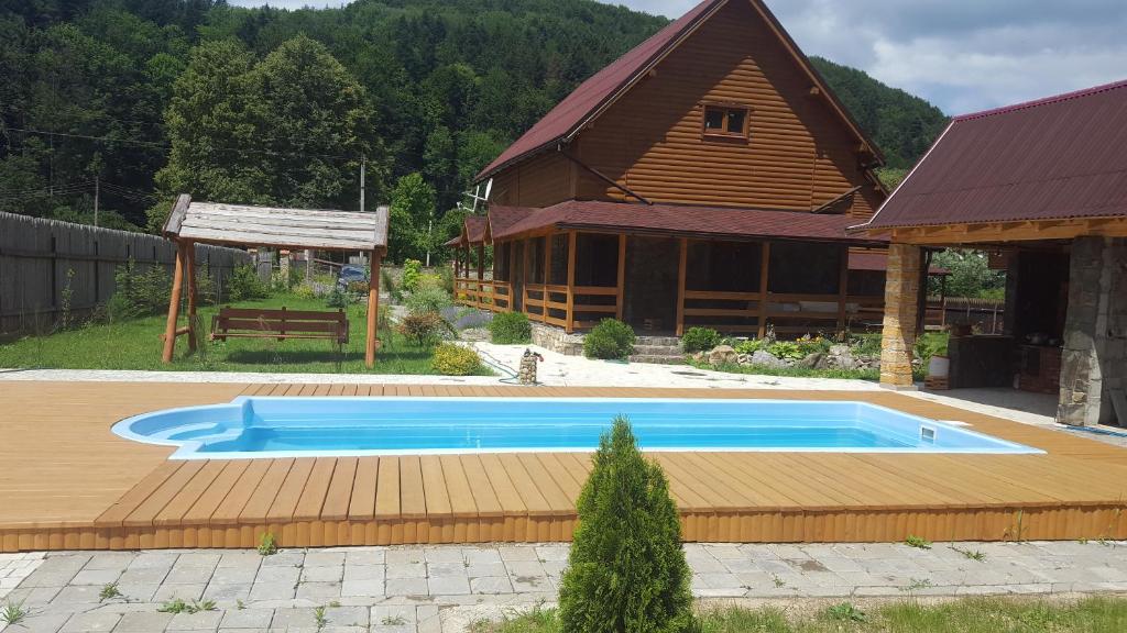 a large swimming pool in front of a house at Guest House in Carpathians in Migovo