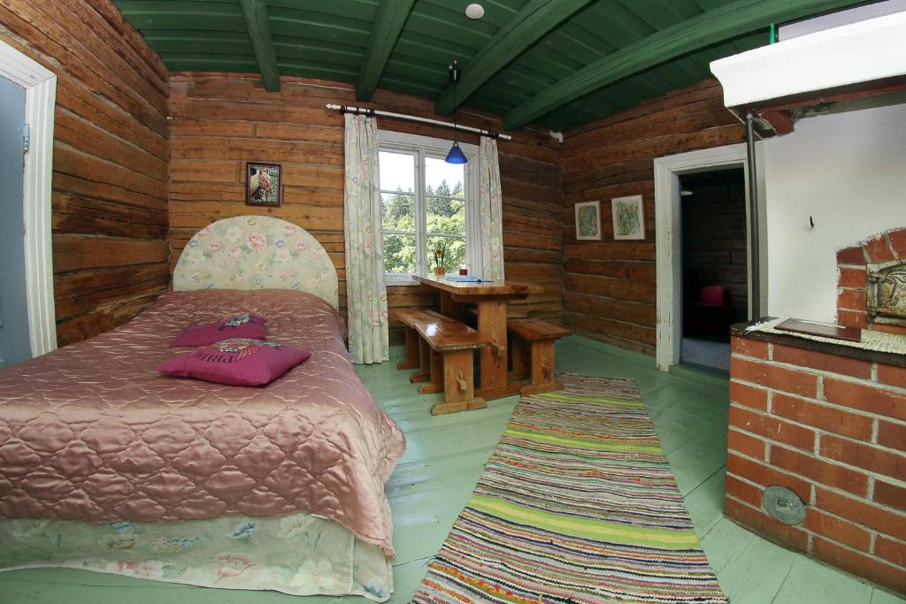 1 dormitorio con 1 cama en una habitación de madera en Vuohensaari Camping Ahtela's cottage, en Salo
