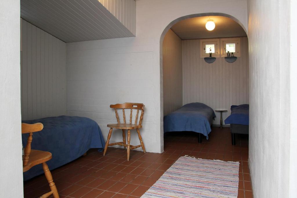 サロにあるVuohensaari Campingのベッド2台と椅子が備わる小さな客室です。