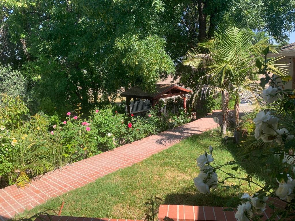 Un jardín con un camino de ladrillos con un banco. en wonderful home WIFI high speed internet 20 minutes to Malibu beach, en Woodland Hills