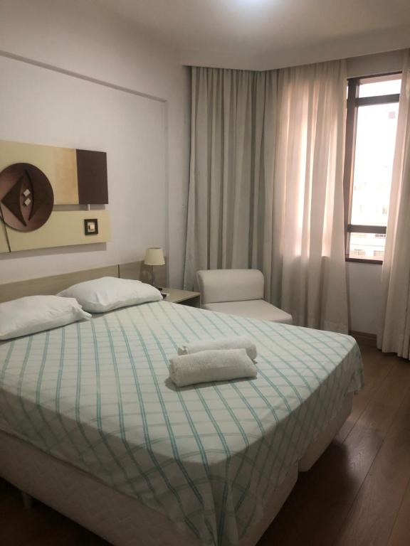 a bedroom with a bed with a towel on it at Executive Flat Campinas in Campinas