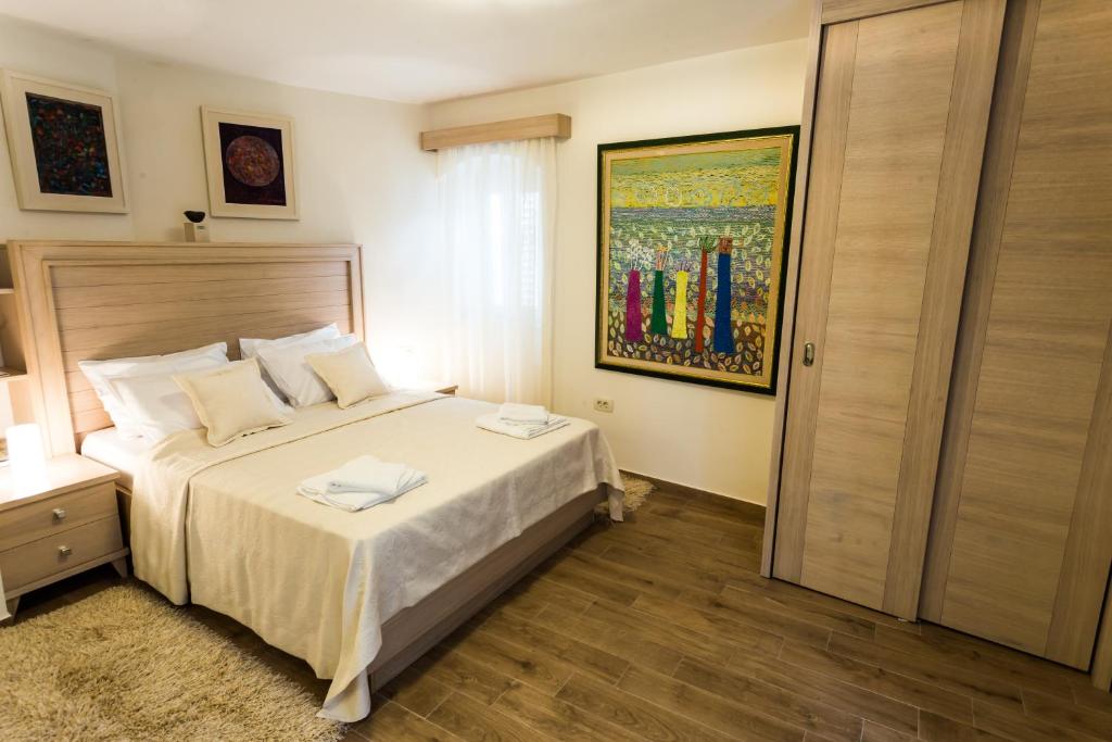 a bedroom with a bed, a desk and a painting on the wall at Apartmani Art Karampana in Kotor