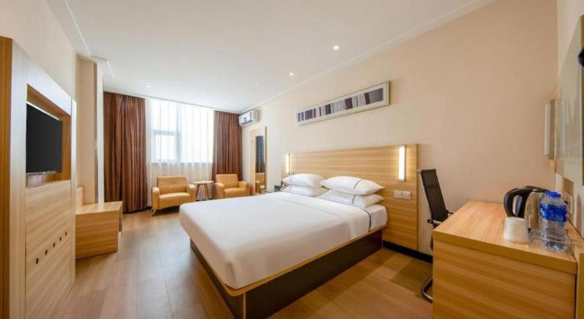 a hotel room with a bed and a television at City Comfort Inn Zhanjiang Shimao Building Chikan Old Street in Tchia-k'am