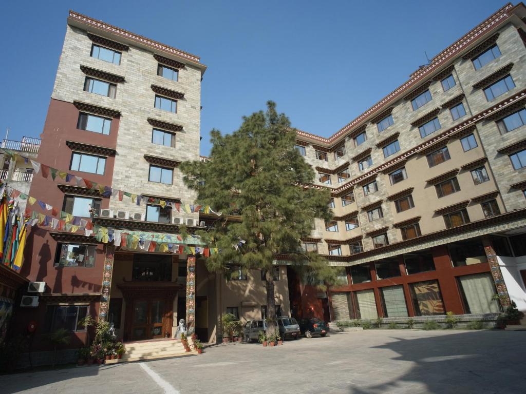 a large building with a tree in front of it at Hotel Tibet International in Kathmandu