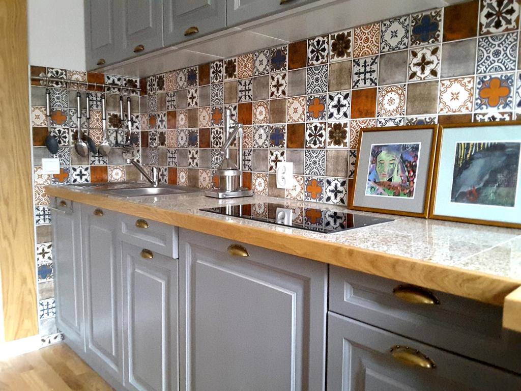 a kitchen with a sink and tiles on the wall at Atelier Aleksandry in Gdynia