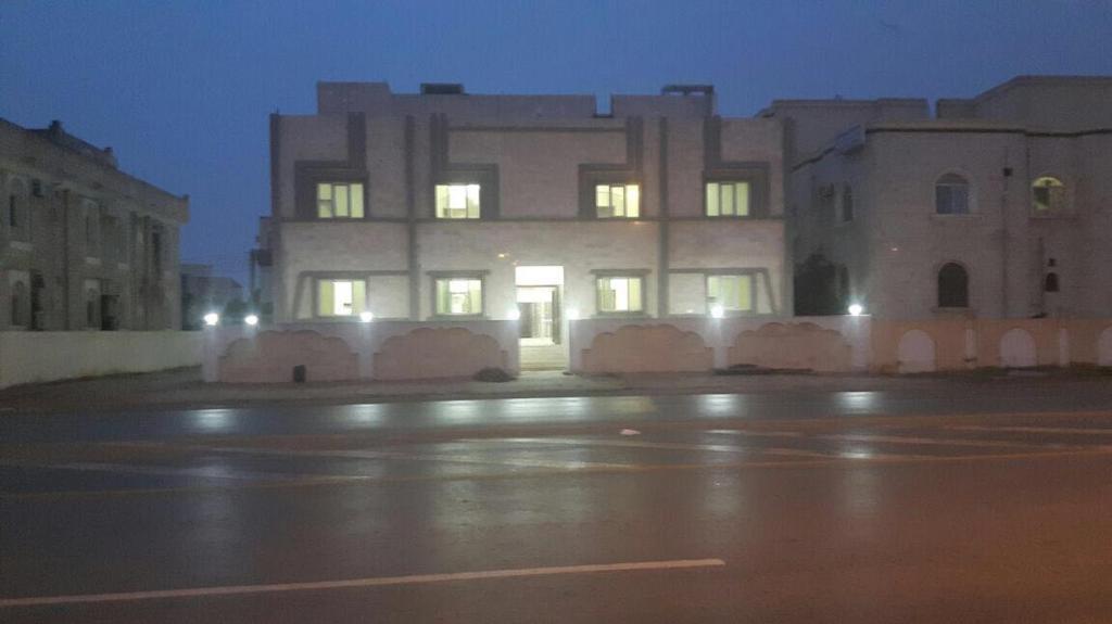 a building with its lights on in a city at night at Al Noor Saadah Furnished Apartments in Salalah