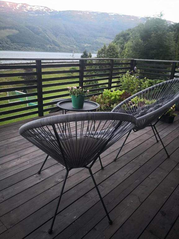 a metal bench sitting on a deck with a table at Koselig hus med flott utsikt in Vossevangen