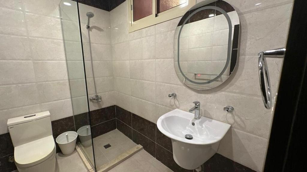 a bathroom with a sink and a toilet and a mirror at Al Murjan Compound Villa in Jeddah