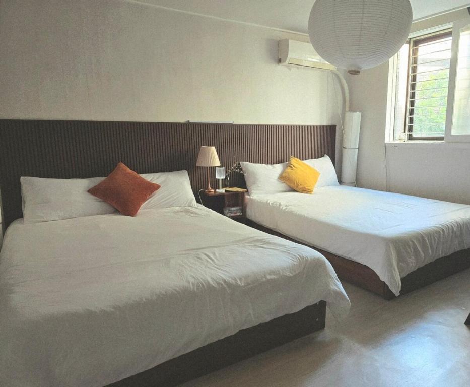 a bedroom with two beds with white sheets and colorful pillows at Slow accommodation,Free parking,kspo dome,Kangdong Sacred Heart Hospital,Seoul Asan Hospital,COEX,Lotte World Tower,kspo in Seoul