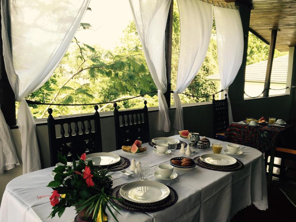 einen Tisch mit einem weißen Tischtuch und Platten darauf in der Unterkunft Retro in Zanzibar City