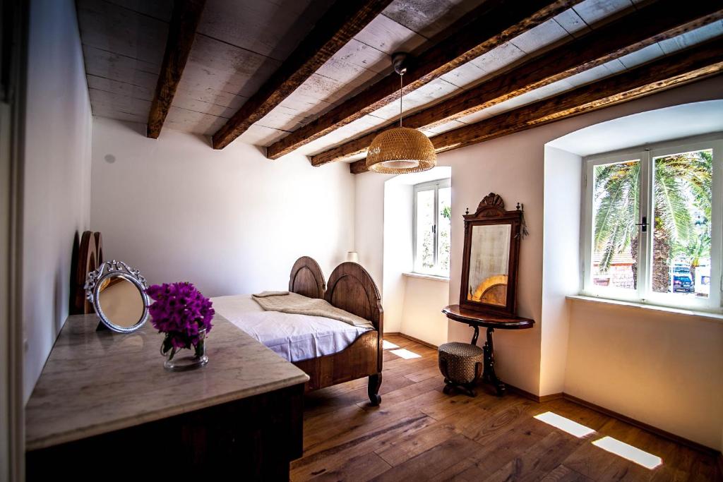 a bedroom with a bed and a mirror on a table at Villa Arboretum in Milna