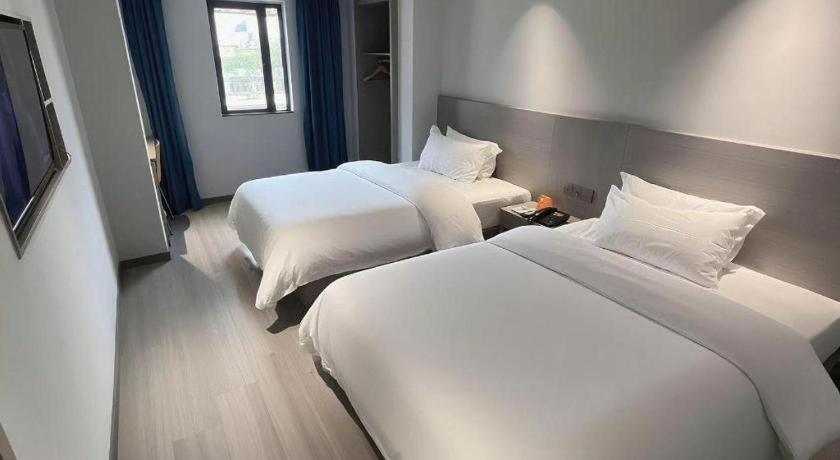 Postel nebo postele na pokoji v ubytování 7 Days Inn Guiyang Qianlingshan Park Beijing Road Metro Station