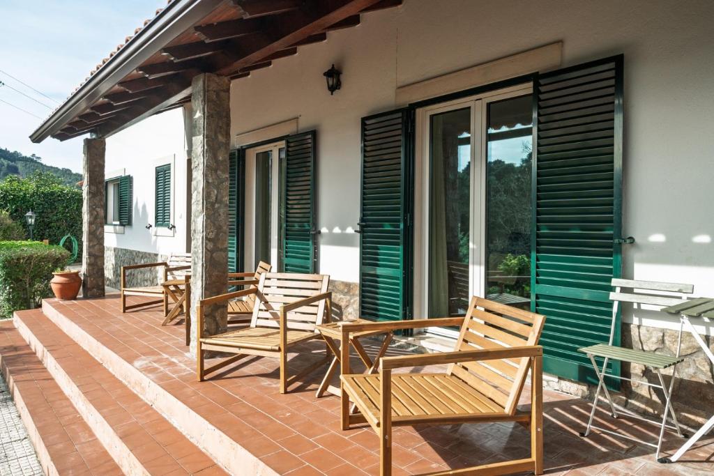 a deck with chairs and tables on a house at Bela Vista - Countryside home in Gradil