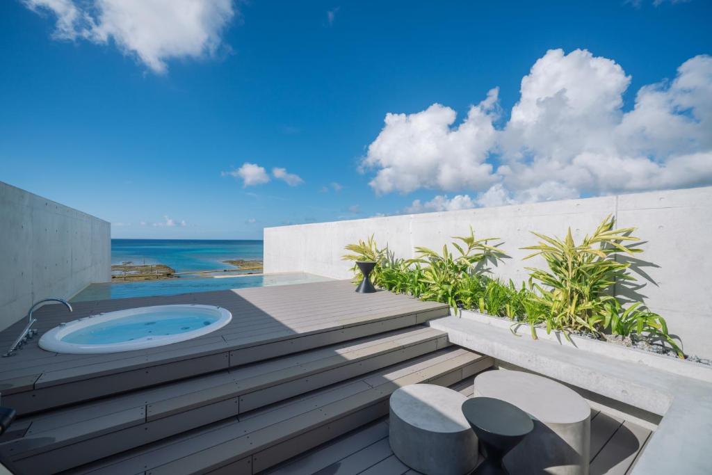 a balcony with a jacuzzi tub on the beach at CELEVI Yomitan セレビィ 読谷 in Yomitan