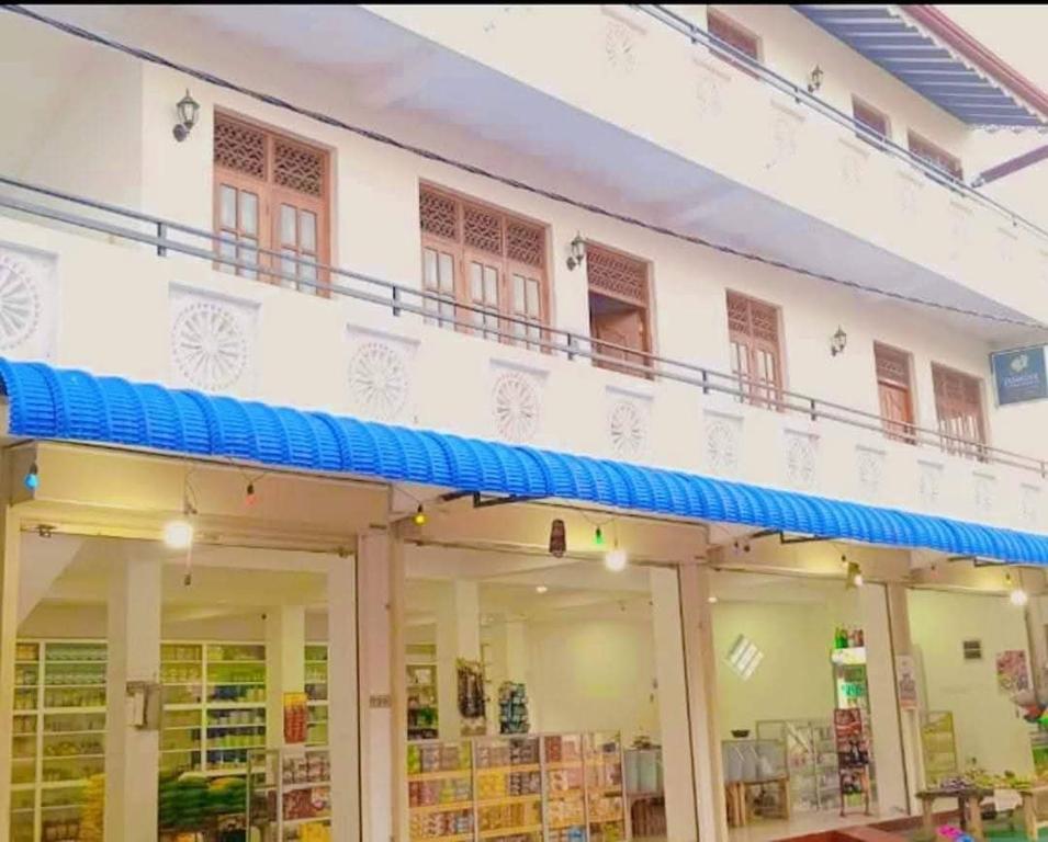 a large white building with a blue balcony at Jasmine Apartments in Negombo