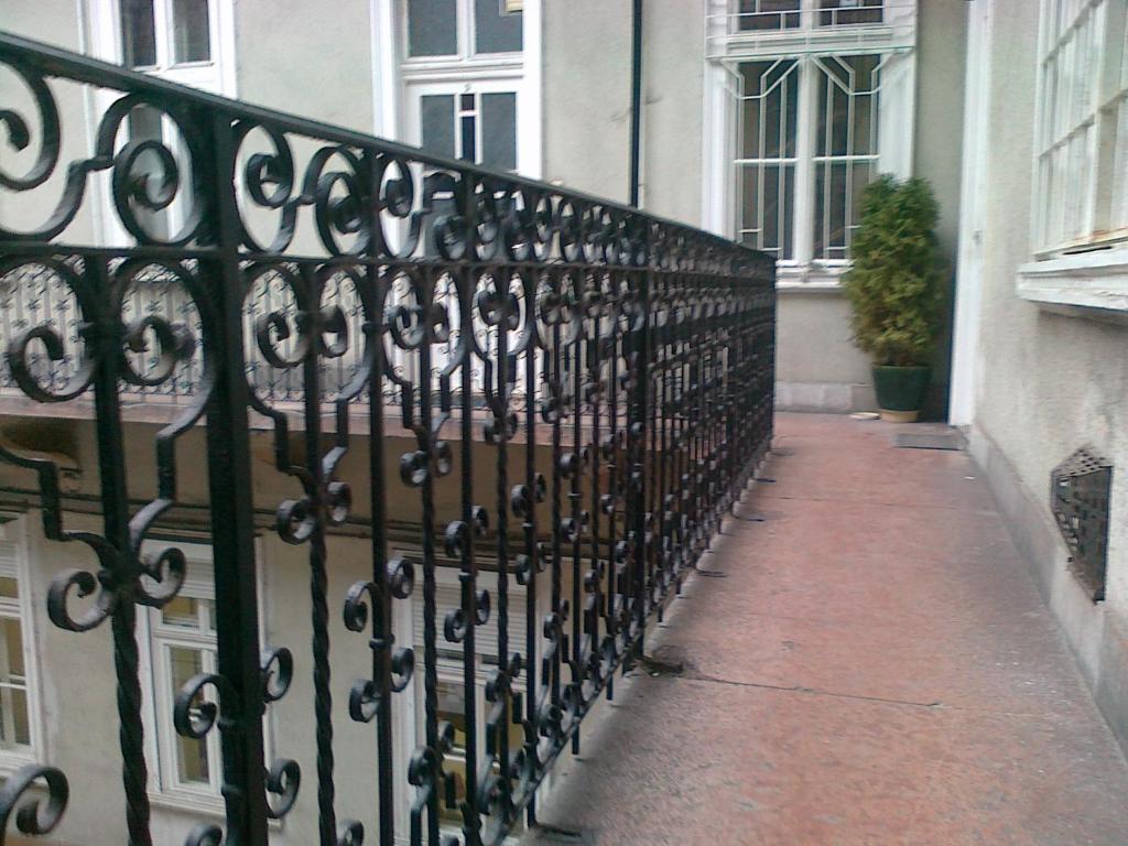 a black wrought iron fence next to a building at Locomotive Hostel in Budapest