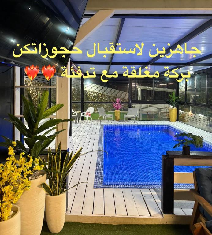a swimming pool in a building with a sign that reads emergency at Moon View Resort in Ein Kinya