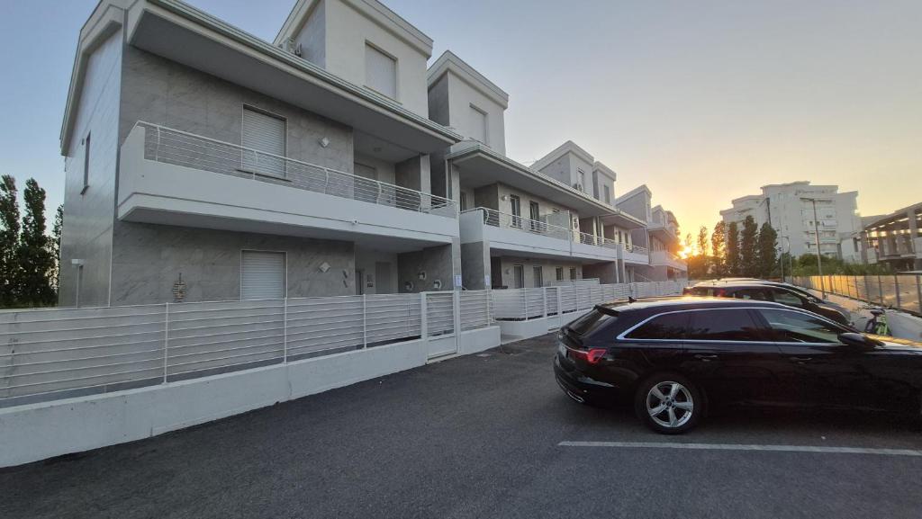 a black car parked in a parking lot next to a building at La dimora di Matteo in Marina di Montenero
