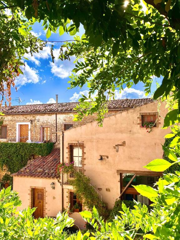 an old stone building with trees in front of it at Casa Bonomo in Castelbuono