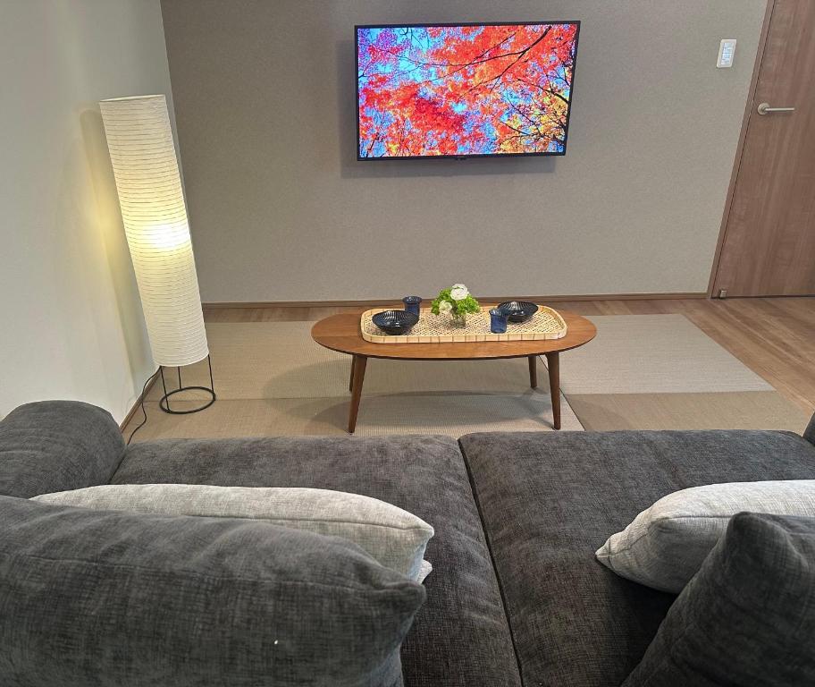 una sala de estar con un sofá y una mesa en NK Comfort Villa BEPPU, en Beppu