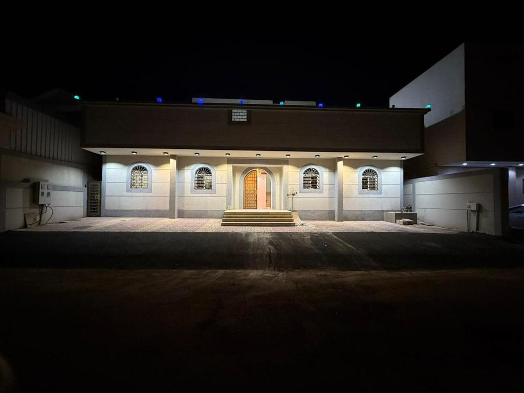 a large building with a red door at night at شقة مفروشة أنيقة للإيجار اليومي في مكة -الشرائع in Ash Sharāʼi‘