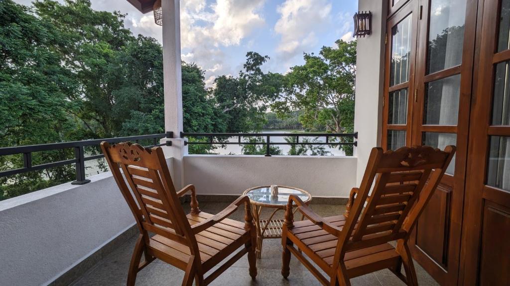 a porch with two chairs and a glass table on a balcony at Lake side haven villa in Tangalle