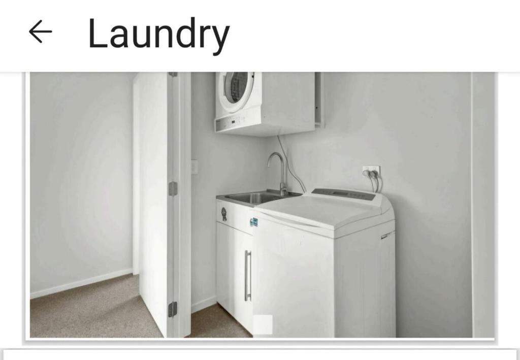 a kitchen with a washing machine and a microwave at Modern & Comfort in Central Alexandra in Alexandra