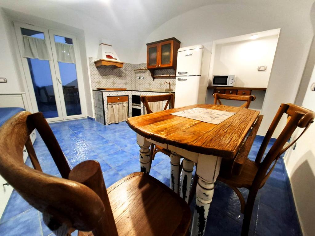 a kitchen with a wooden table and some chairs at Ely House Costa d'Amalfi Casa Vacanze in Albori