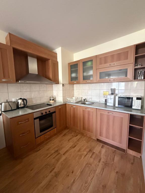 eine große Küche mit Holzschränken und Holzböden in der Unterkunft Prime location one bed apartment with hydro bath in Royal Plaza in Borowez