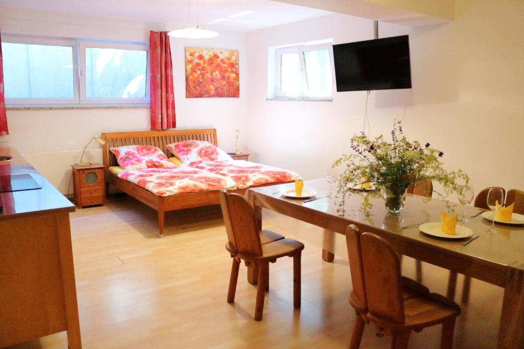 ein Wohnzimmer mit einem Tisch und einem Bett sowie ein Esszimmer in der Unterkunft Großzügige Souterrainzimmer in München