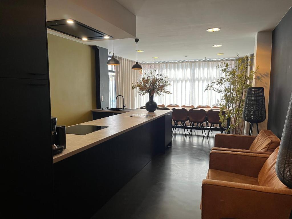 a kitchen with a counter and chairs in a room at La Petite Fleur in Baarle-Nassau