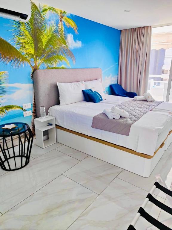 a bedroom with a large bed and a palm tree at Blue Ocean Costa Adeje 504 in Playa de las Americas