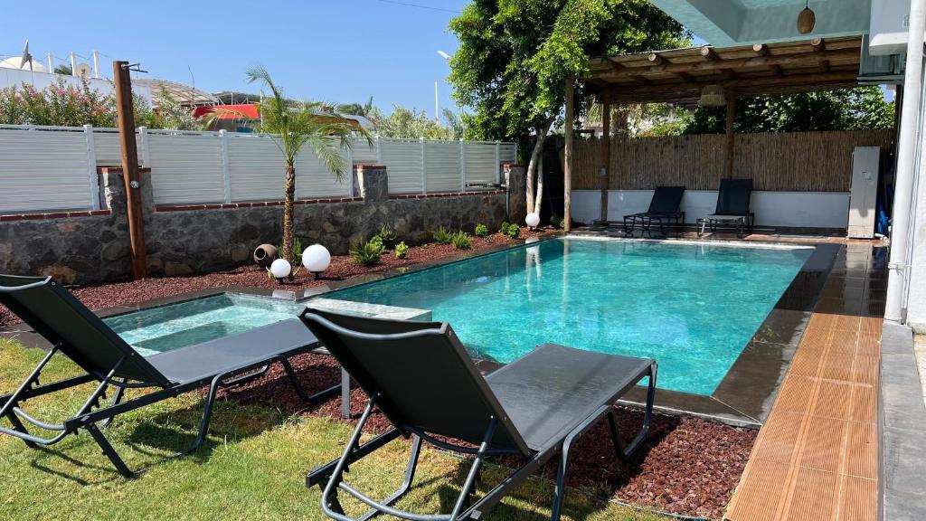 une piscine avec deux chaises et une table dans l'établissement Casa Oliva City 3 with Sauna Jakuzzi Pool & BBQ, à Fethiye