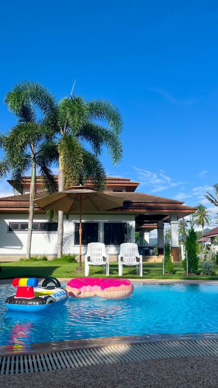 a swimming pool with two inflatable boats in it at Per La Villa Khao Lak in Khao Lak